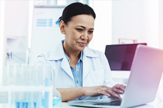 lab tech reviewing results on laptop